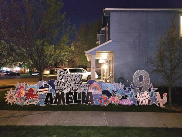 An image of a yard sign with a big number 9, the phrase "Happy Birthday Amelia" and other graphics around it.