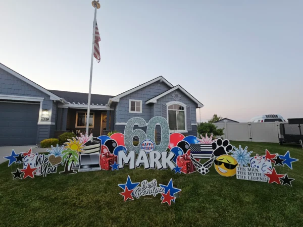 An image of a yard sign with a big number 60, the phrase "Happy Birthday Mark" and other graphics around it.